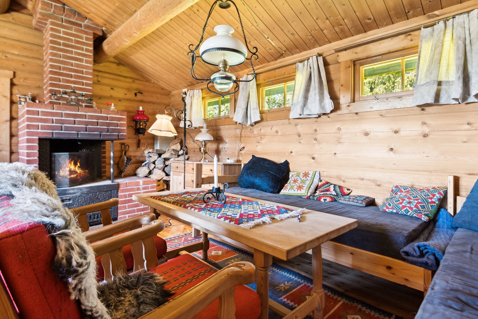 Stuen har solide tømmervegger og åpen peis. Galleribilde