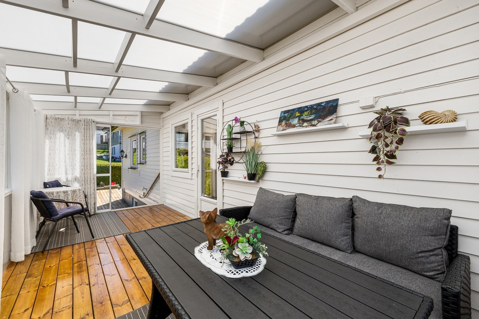 Innglasset terrasse på ca 14 m2 utenfor kjøkken med åpningsbare skyvevinduer og skyvedører og utgang til hagen. Galleribilde