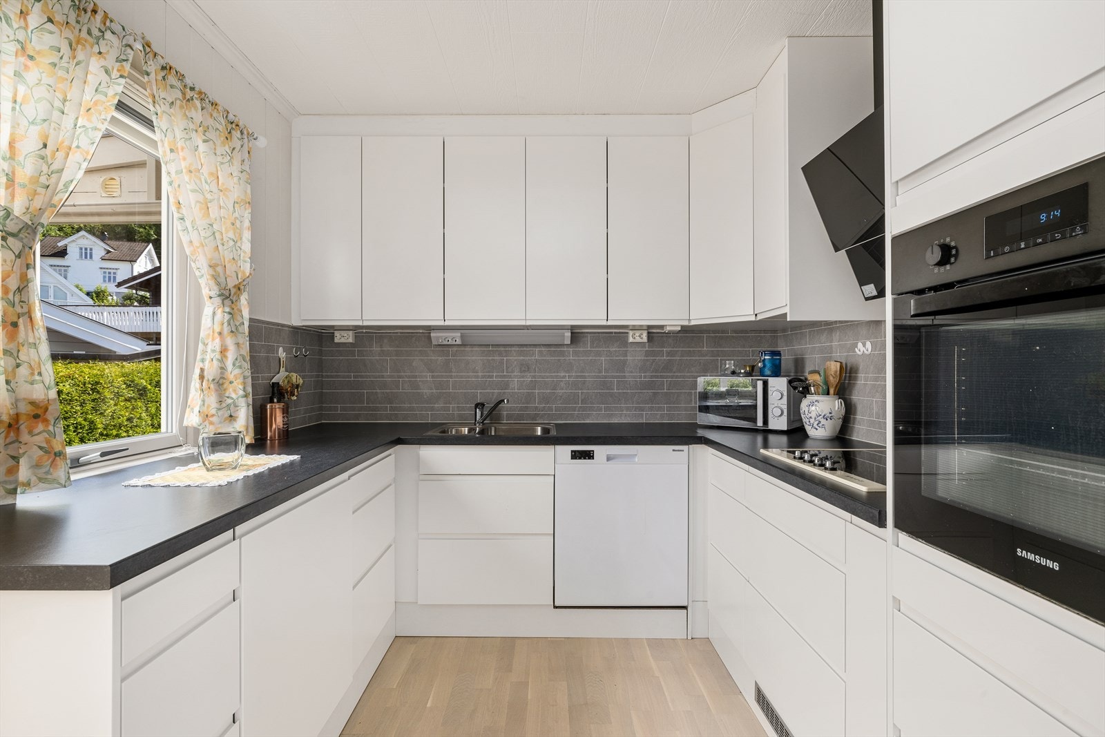 Kjøkkenet er utstyrt med integrerte hvitevarer som induksjonstopp og stekeovn, og har god kombinasjon av arbeidsplass og benkeplass. Galleribilde