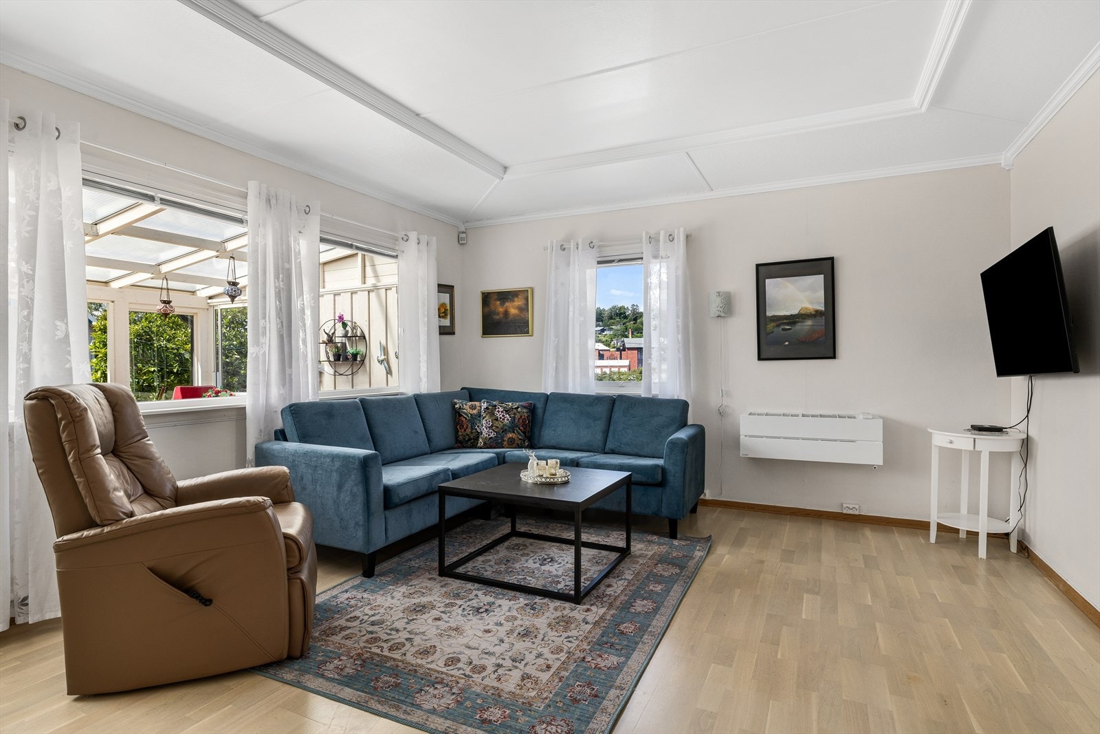 Stuen har store vinduer som bidrar til rikelig med naturlig lysinnslipp. Galleribilde