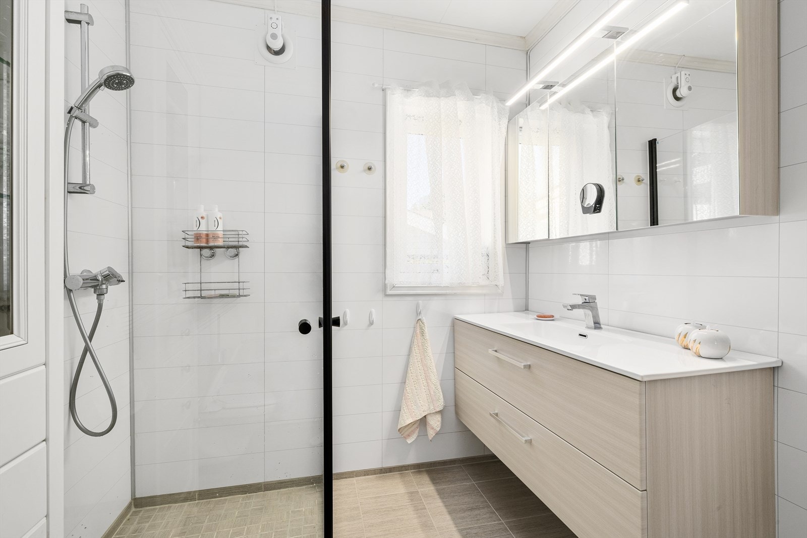 Innredet med nedsenket dusjgrube med glassdører, servantskap og vegghengt toalett. Galleribilde