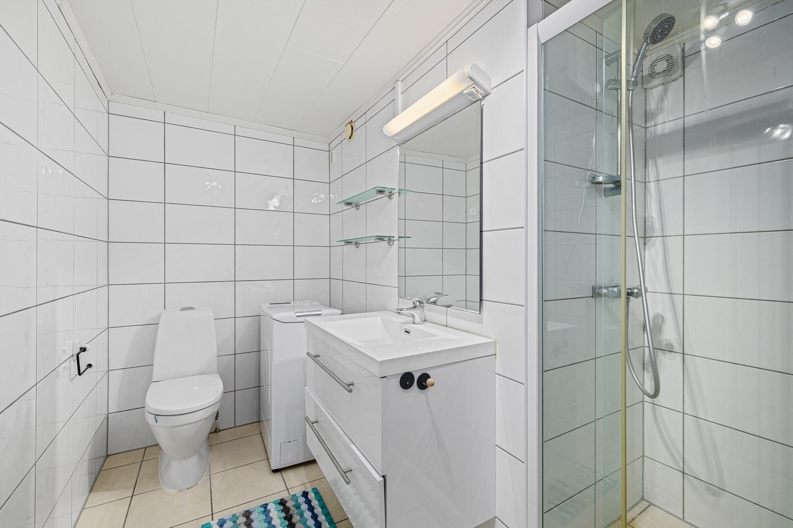 Innredet med servantskap, toalett og opplegg for vaskemaskin. Eget opphøyet dusjrom med glassdør. Galleribilde