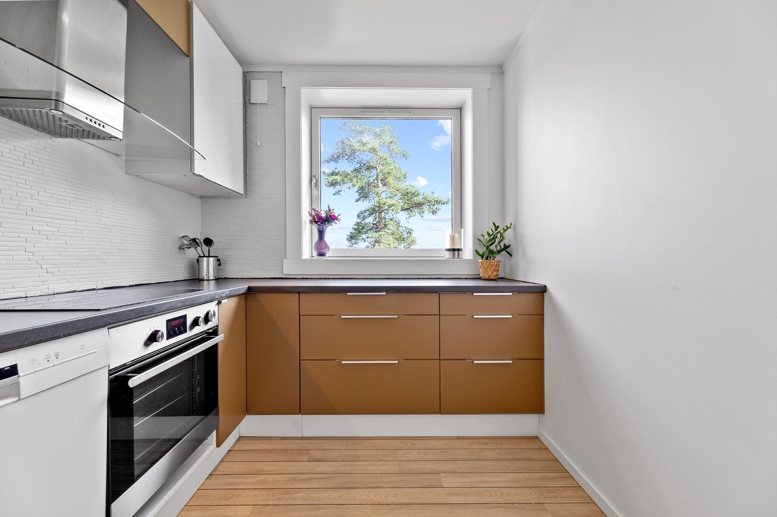 Kjøkkenet har integrerte hvitevarer oppvaskmaskin, komfyr og koketopp. Kjøleskapet er fritt stående. Galleribilde
