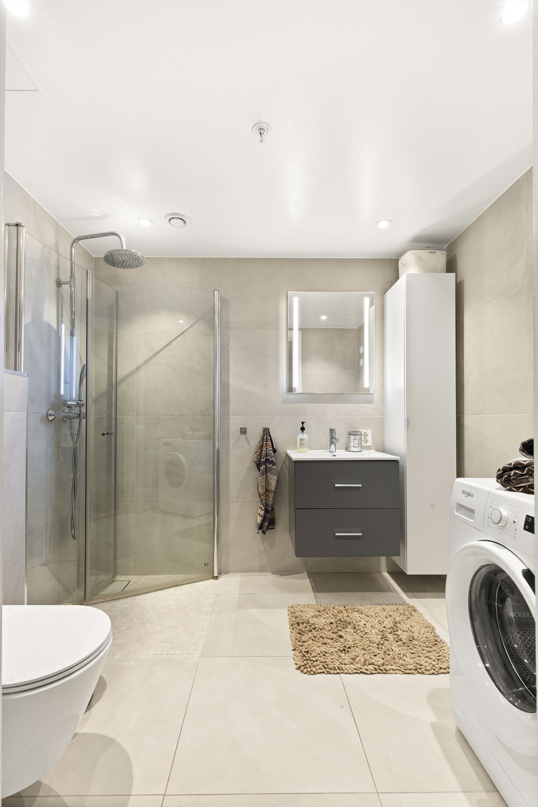 Badet er utført med moderne store fliser og tidsriktige fargevalg Galleribilde