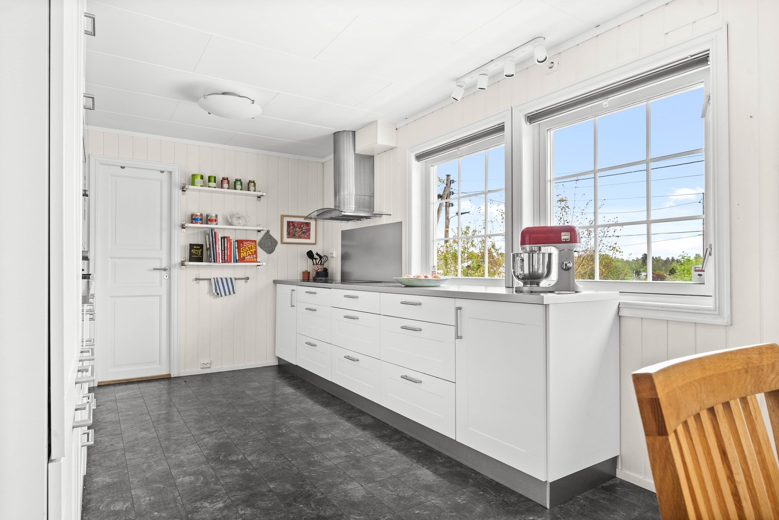 Det er malt flate mellom benkeplate og overskap. Overbelysning og stikkontakter over benk. Galleribilde