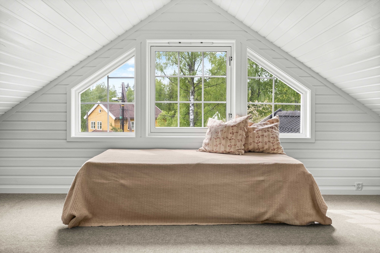 Vinduer som gir lys inn og gjør loftstuen til et hyggelig rom å oppholde seg i. Galleribilde