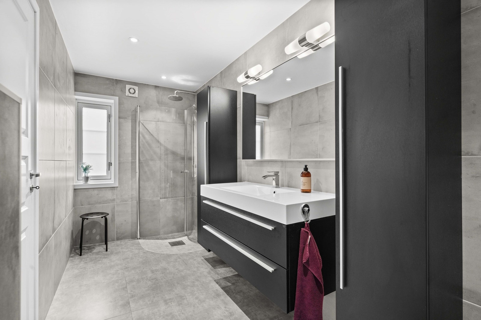 Det er flislagt gulv med varme og flislagte vegger, nedsenket himling med downlights. Galleribilde