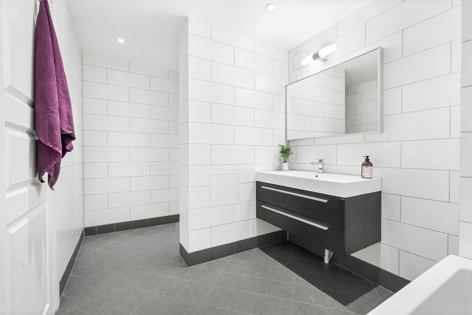 Det er flislagt gulv med varme og flislagte vegger, nedsenket himling med downlights. Galleribilde