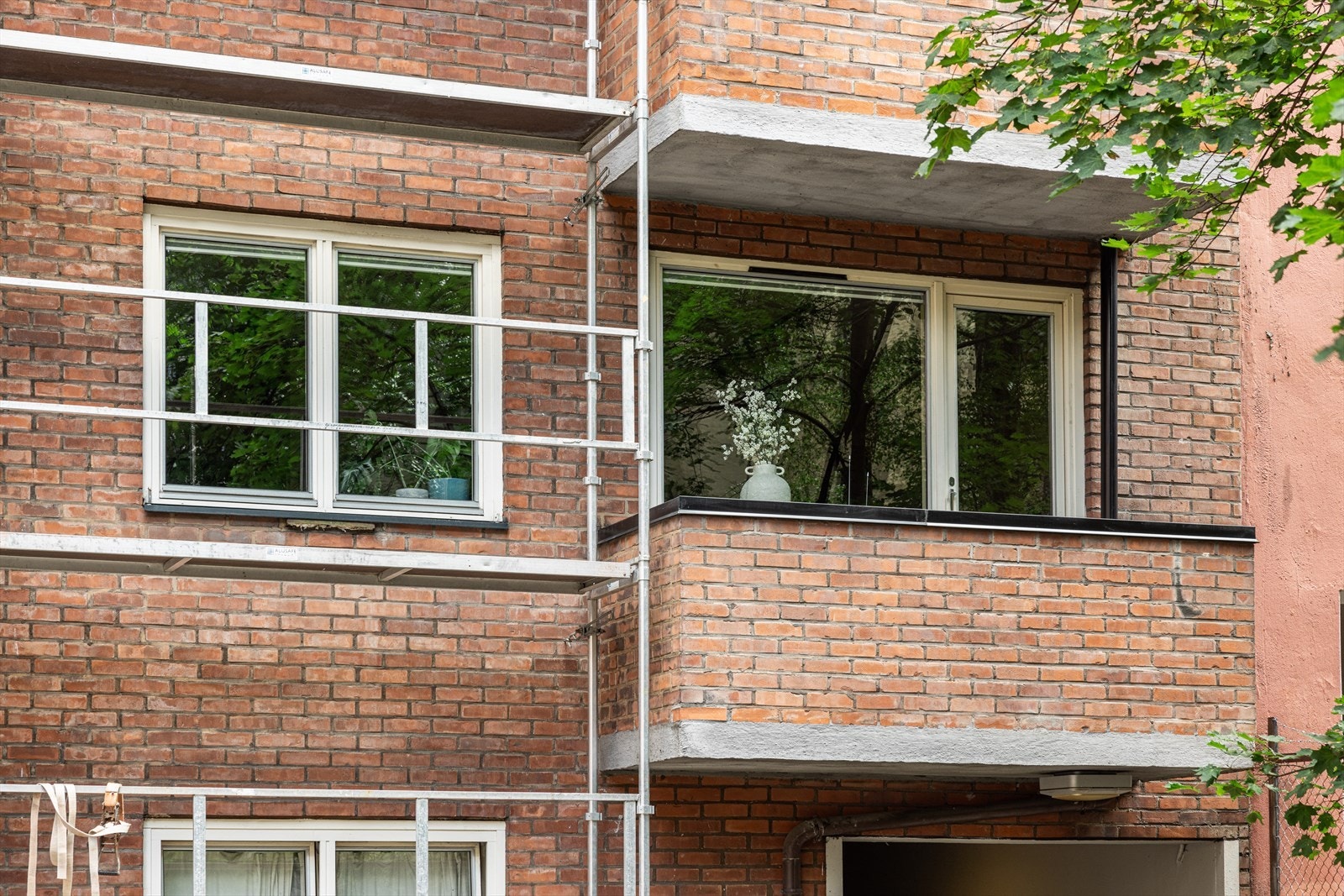 Balkong med utsikt mot bakgård. Pågående takprosjekt er planlagt avsluttet i slutten av september. Stillas blir da fjernet. Galleribilde