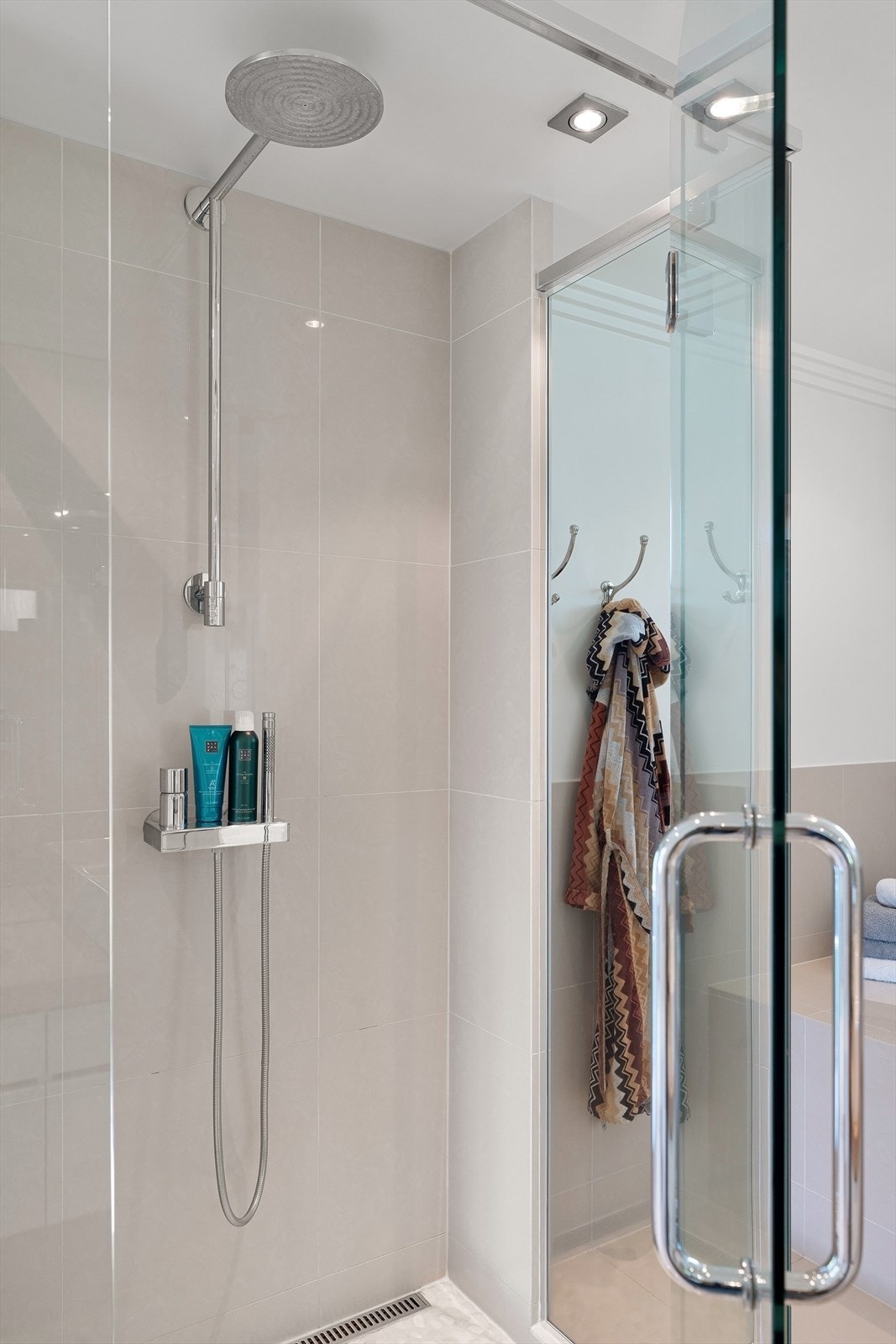 Badet er utstyrt med vegghengt toalett, dobbelservant på eik benkeplate med skuffer, dusj med glassvegger og innmurt badekar. Galleribilde