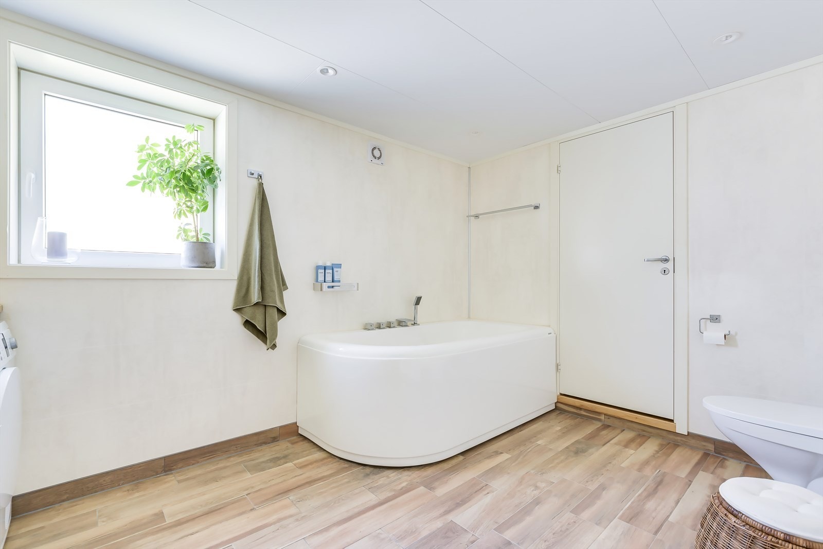 Badet er innredet med vegghengt toalett, badekar og vaskeromsinnredning. Galleribilde