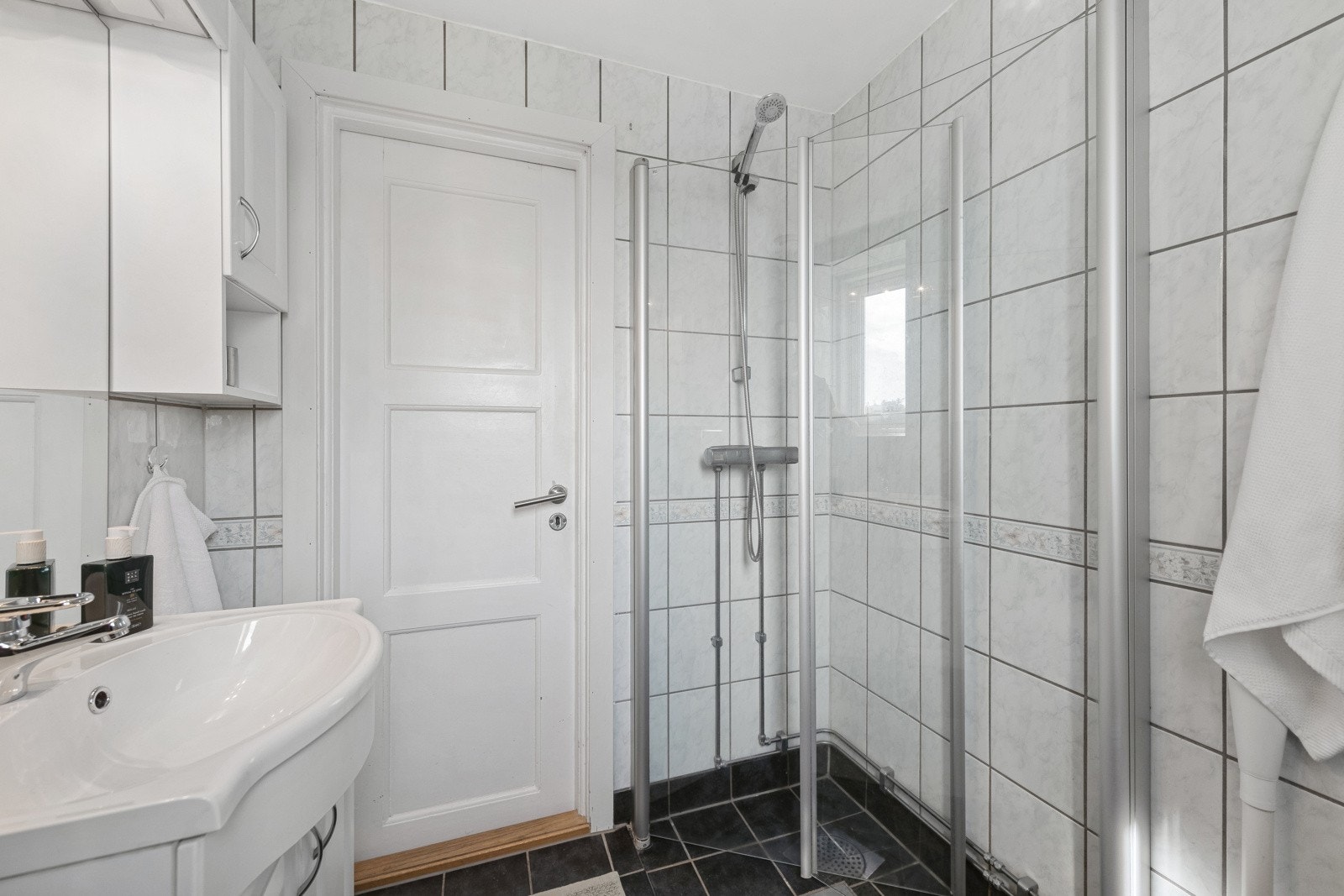 Badet er praktisk innredet med servant med innredning, vegghengt toalett, dusj med skyveglass (dusjarmatur byttet i 2021) og opplegg for vaskemaskin. Galleribilde