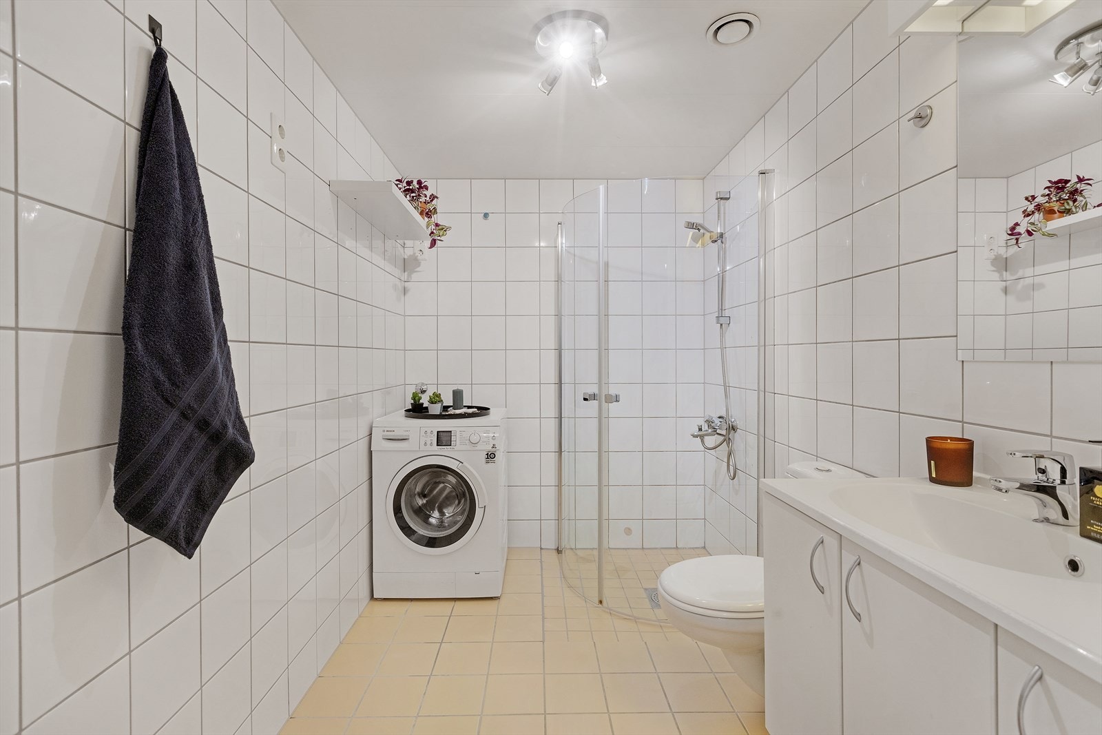 Stort flislagt bad med opplegg for vaskemaskin Galleribilde