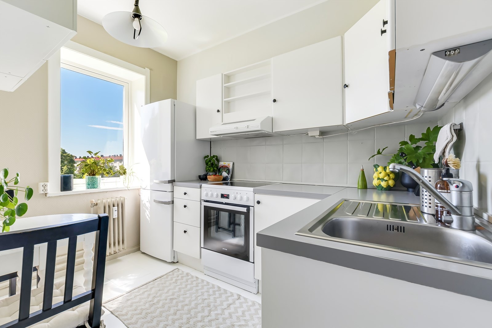 Separat kjøkken med hvite fronter, fliser på bakvegg og laminert benkeplate Galleribilde