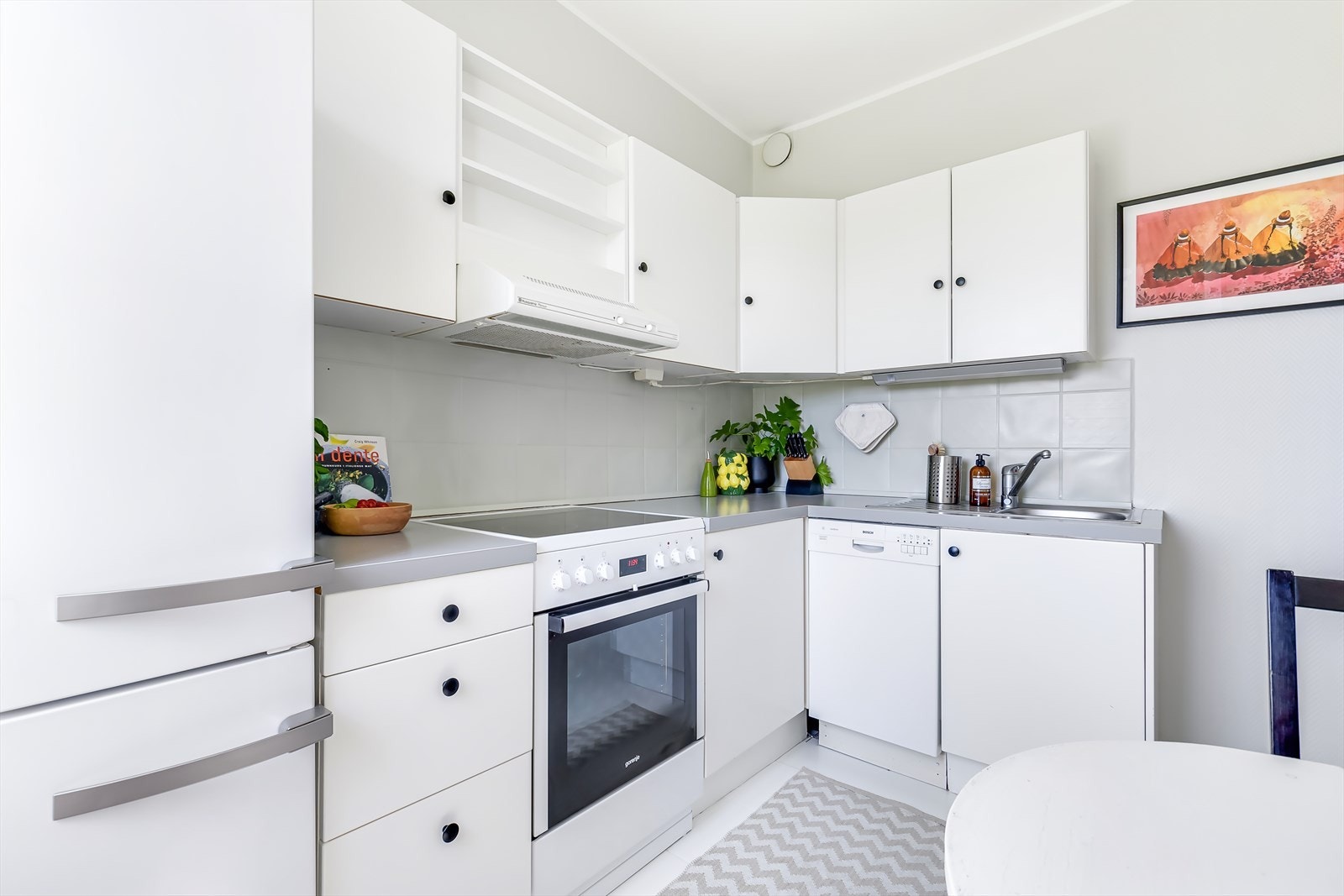 Kjøkkenet er utstyrt med frittstående hvitevarer som komfyr, oppvaskmaskin og kombinert kjøle- og fryseskap Galleribilde