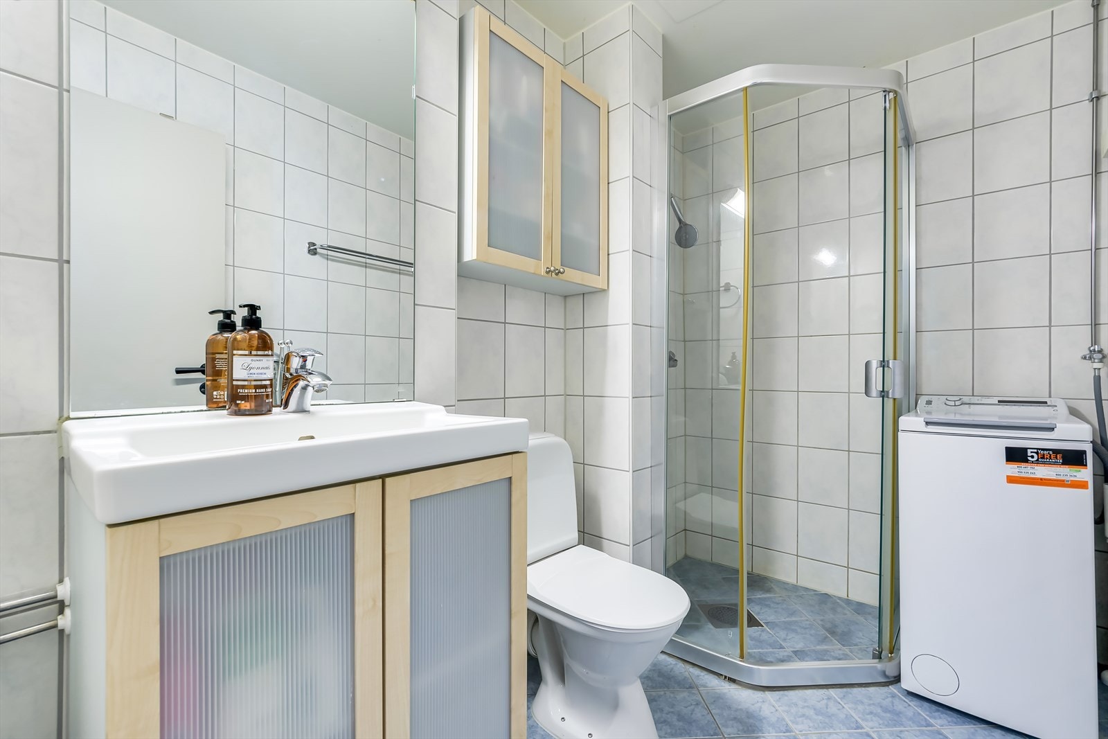 Flislagt bad med opplegg for vaskemaskin. Badet ble pusset opp i regi av borettslaget i 2006 Galleribilde