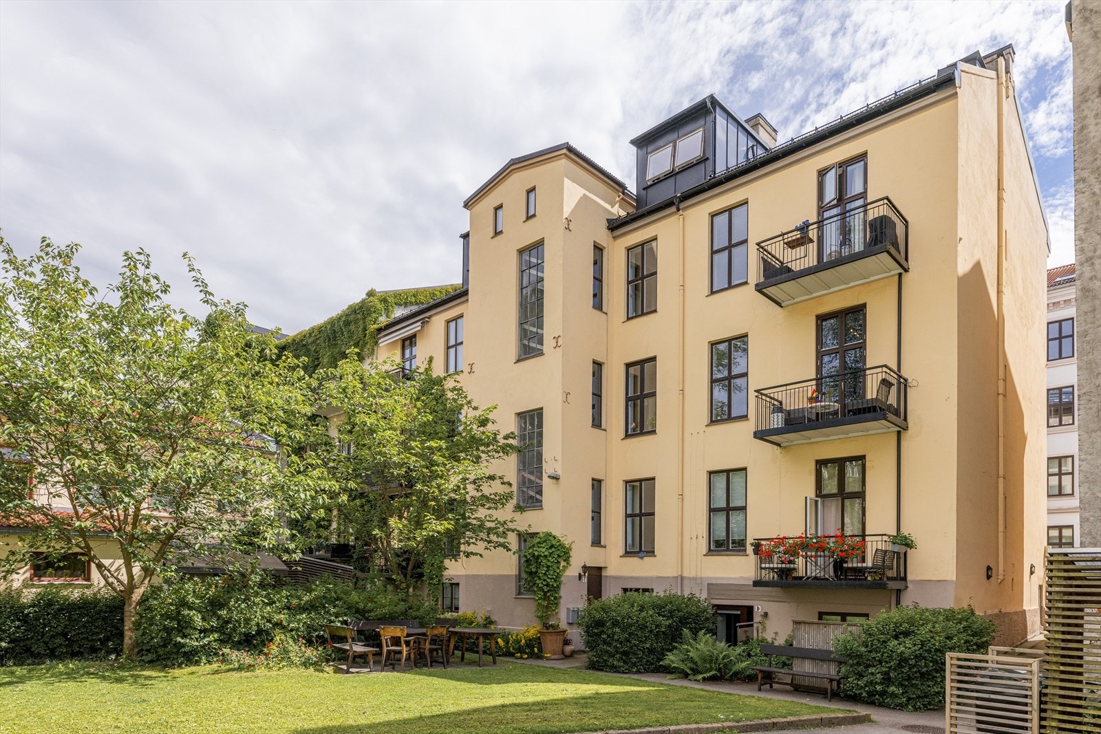 En nydelig bakgård med flere sosiale soner og sittegrupper. Galleribilde