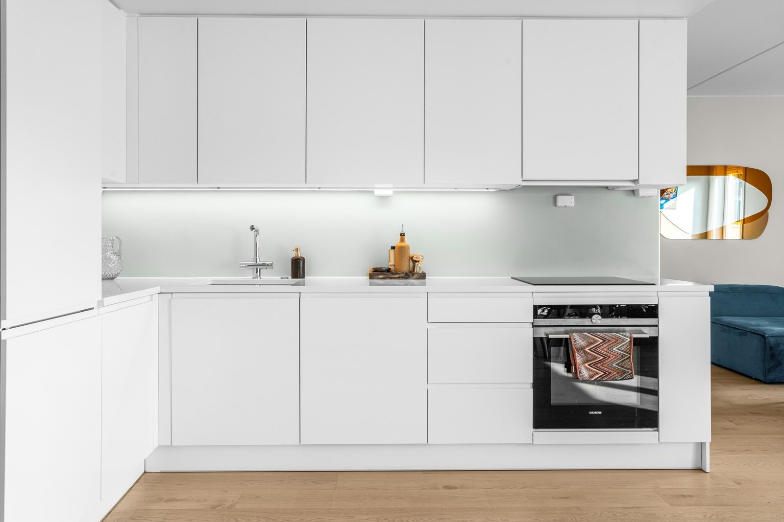 Stilren og moderne kjøkkeninnredning med integrerte hvitevarer fra Siemens og stein benkeplate med underlimt oppvaskkum i kompositt. Armatur med uttrekk- og dusjfunksjon. Galleribilde