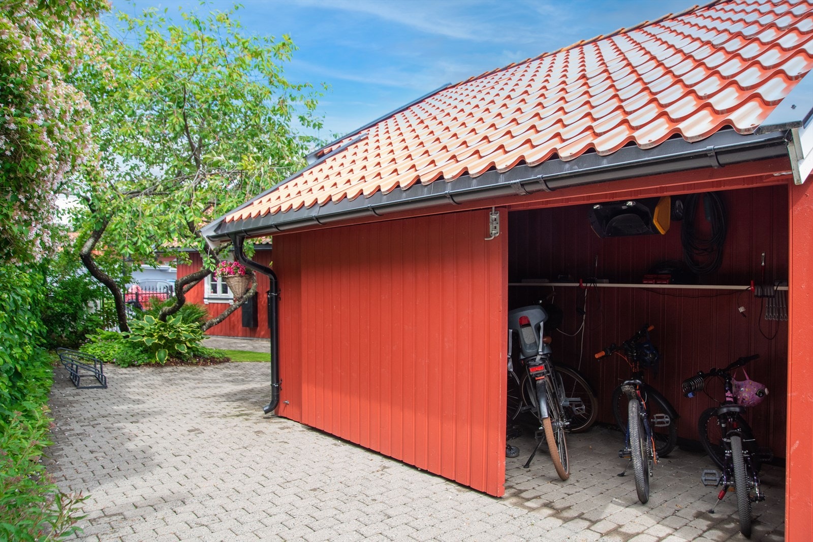 Sykkelbod i bakkant av anneks har en praktisk skyveport i tillegg til dør for enkelt å trille inn og ut sykler eller annet utstyr. Galleribilde