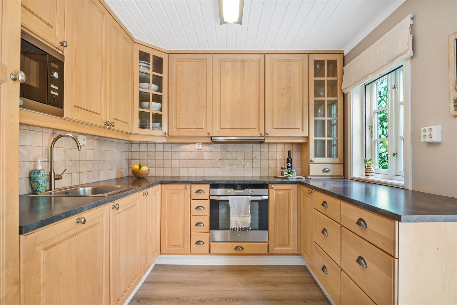 Kjøkkeninnredningen er fra ca. 2010 og har en praktisk U-form med over- og underskap som gir godt med benke-, skap- og skuffeplass. Galleribilde