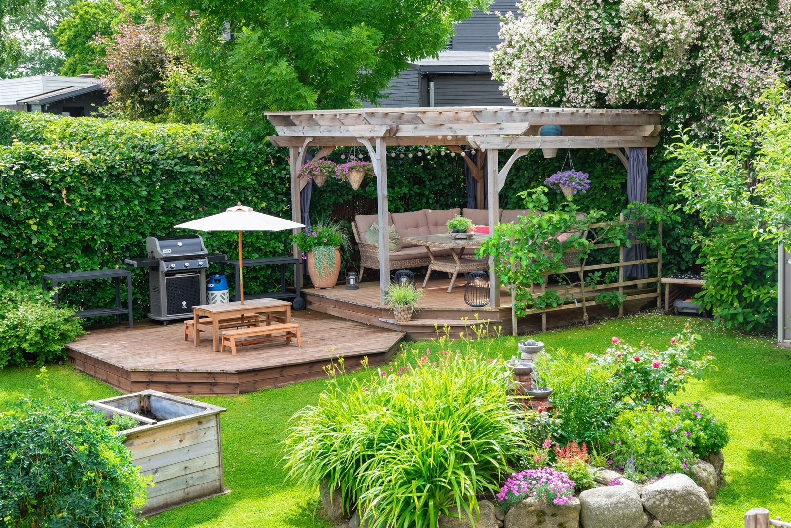 I hjørnet av tomten er det en overbygd pergola med tilhørende platting for store og små. Galleribilde