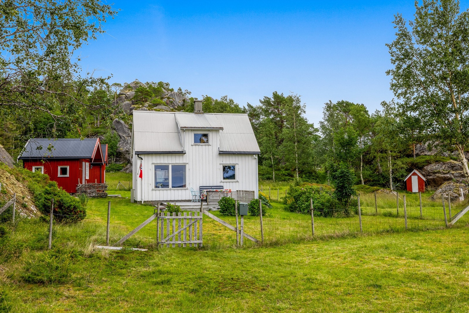 Eiendommen omfattes av hytte, to uthus naust og eldre låve Galleribilde