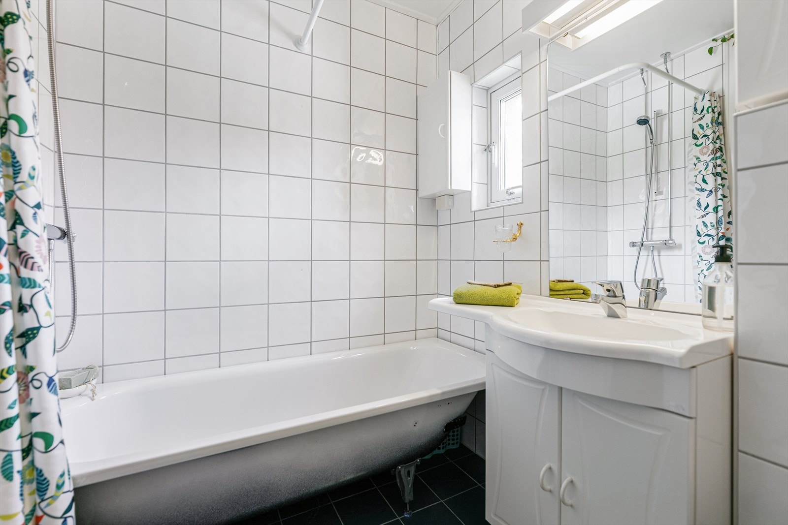Badet har badekar og opplegg for vaskemaskin. Galleribilde