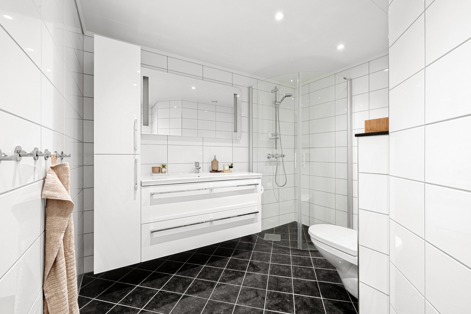 Badet er helfliset og har en slett malt himling med innfelte downlights i himling og varmekabler i gulv. Galleribilde