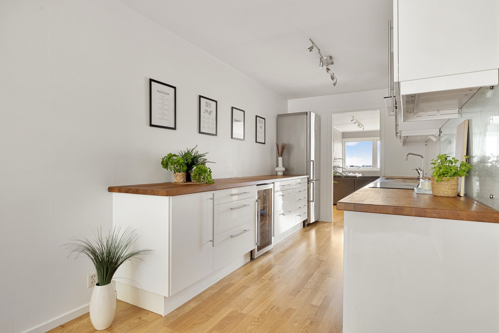 Kjøkkeninnredningen er moderne med slette hvite fronter. Galleribilde