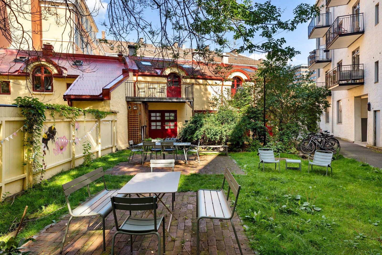 Borettslaget har pent opparbeidet bakgård med hyggelig beplantning i form av frodige blomsterbed, trær og prydbusker. Det er hellebelagte partier med møblement og griller til fri benyttelse, samt plen hvor du kan tusle barbeint. I tillegg lite lekehus for Galleribilde