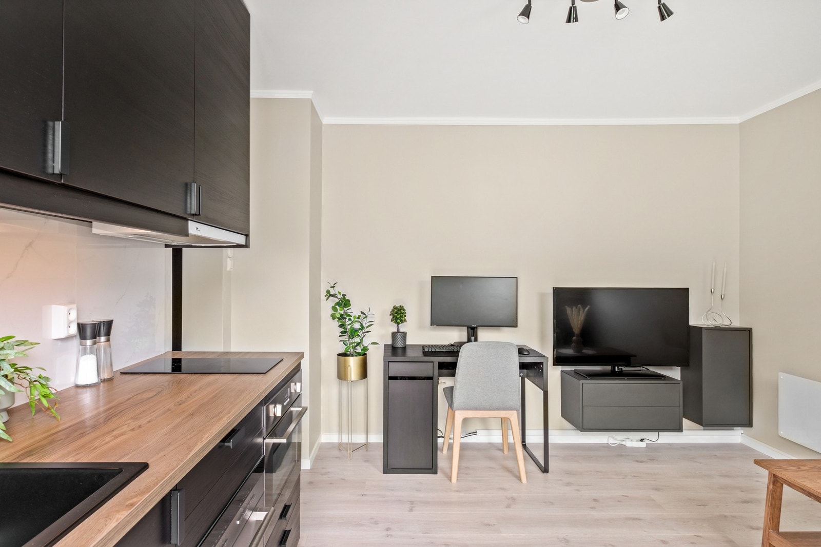 Ny IKEA kjøkkeninnredning fra 2018 med stilfulle slette svarte fronter, laminat benkeplate, sort kvartskompositt vaskekum og ventilator. Galleribilde