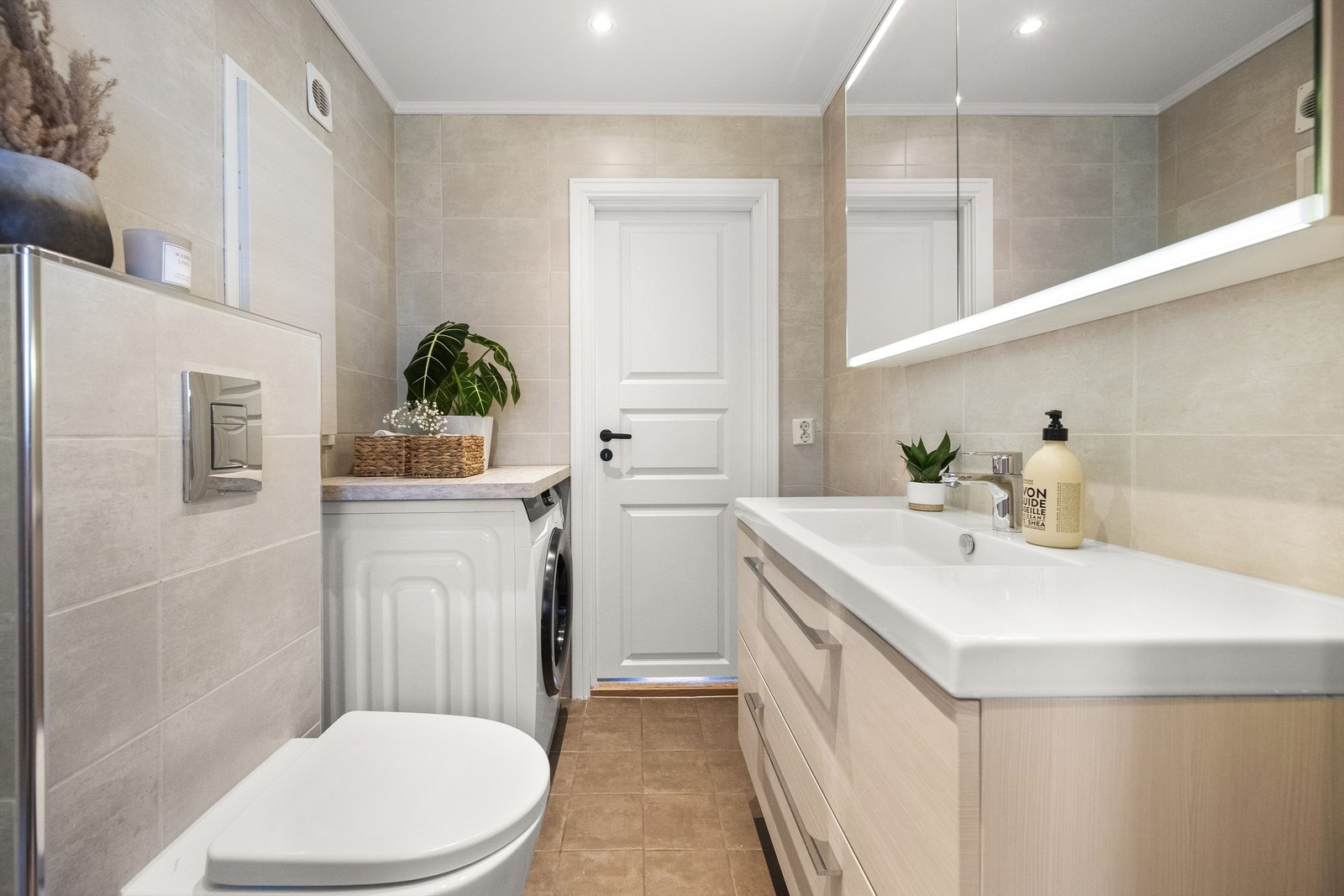 Badet har dusj, vegghengt WC, downlights i taket og opplegg for vaskemaskin. Galleribilde