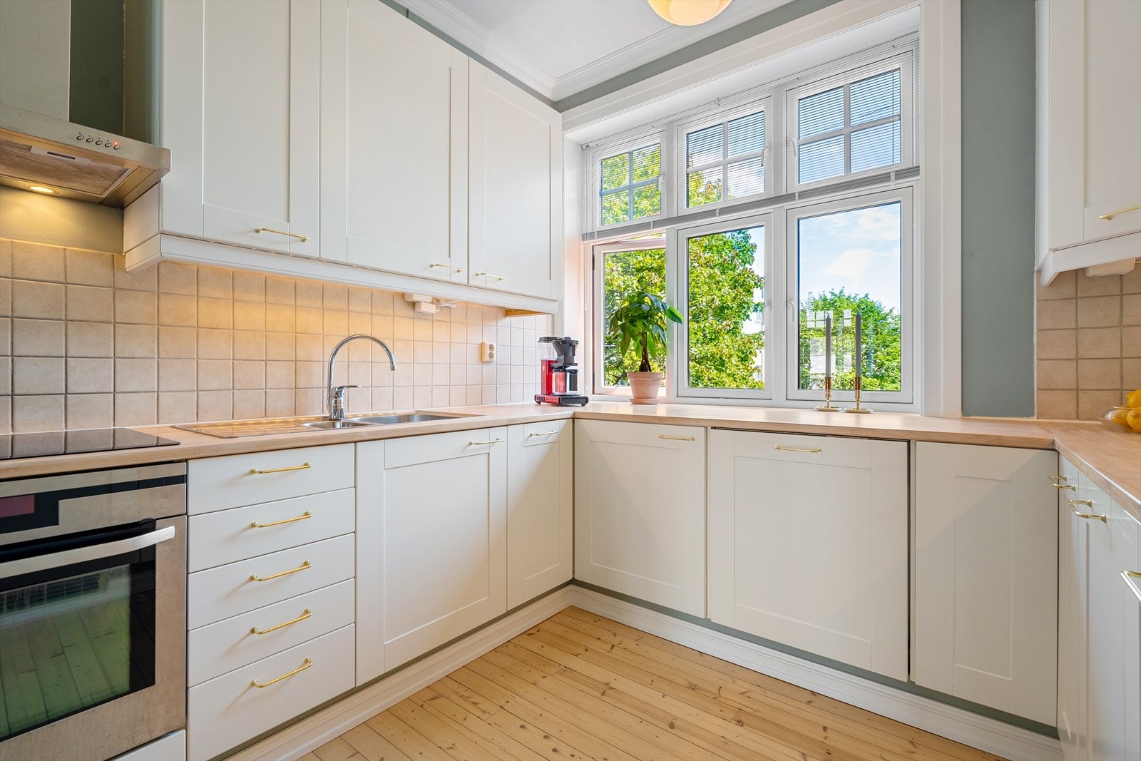 Hvitevarer bestående av nytt, integrert kjøl/fryseskap, oppvaskmaskin, stekeovn og platetopp med mekanisk avtrekk over stekesonen Galleribilde