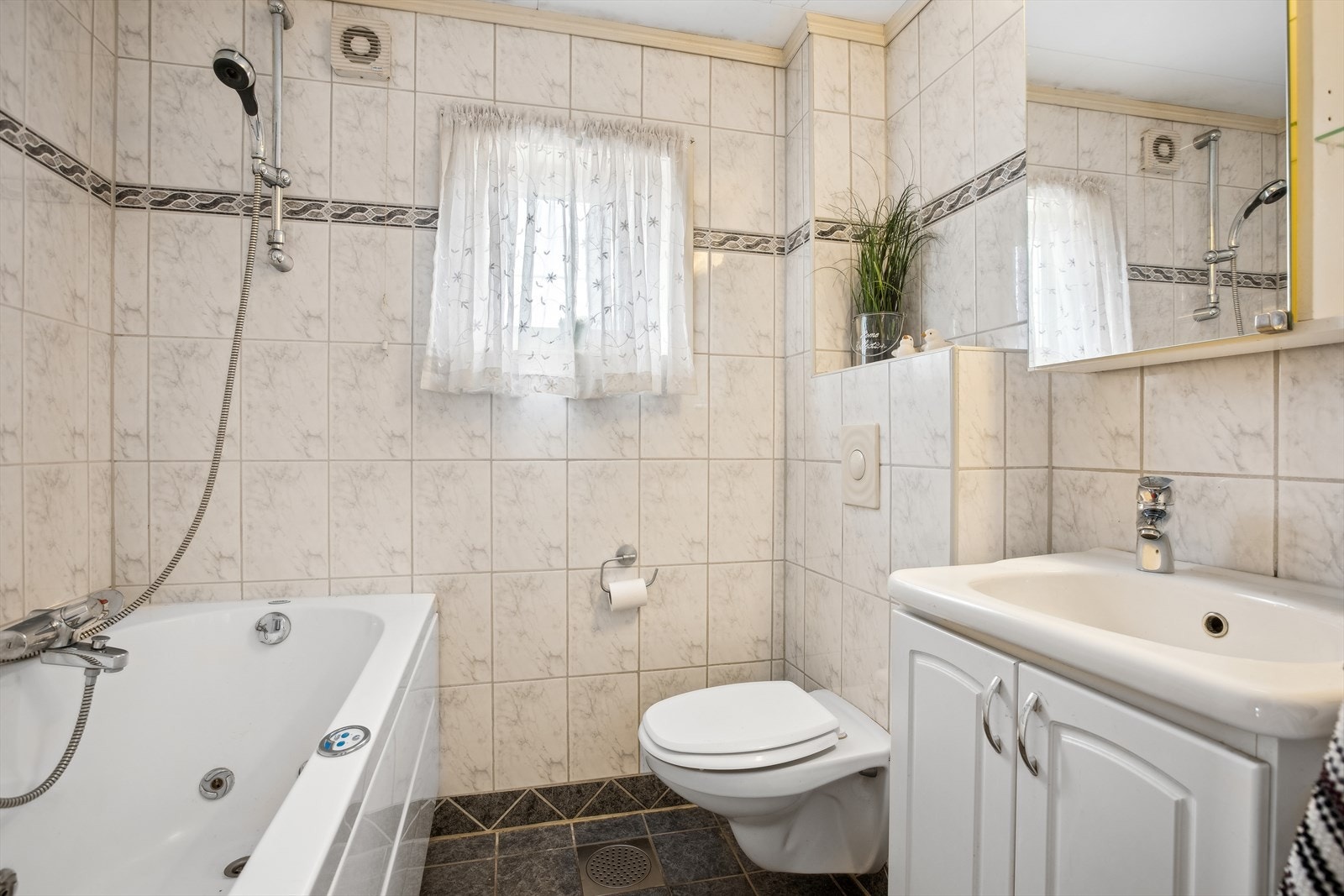 Badet i 2. etasje er utstyrt med gulvvarme, toalett, boble-badekar, baderomsinnredning med servant og speilskap. Galleribilde