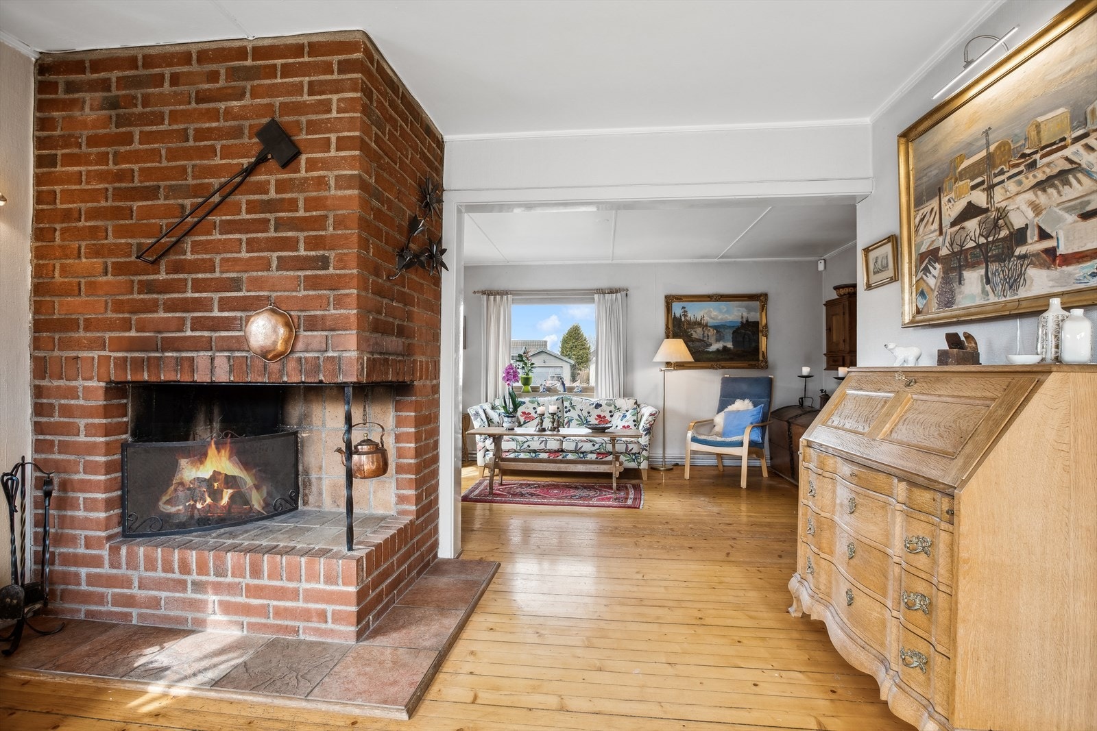 Midt i rommet er det en åpen peis, som gir god varme og hygge på kalde dager. Galleribilde