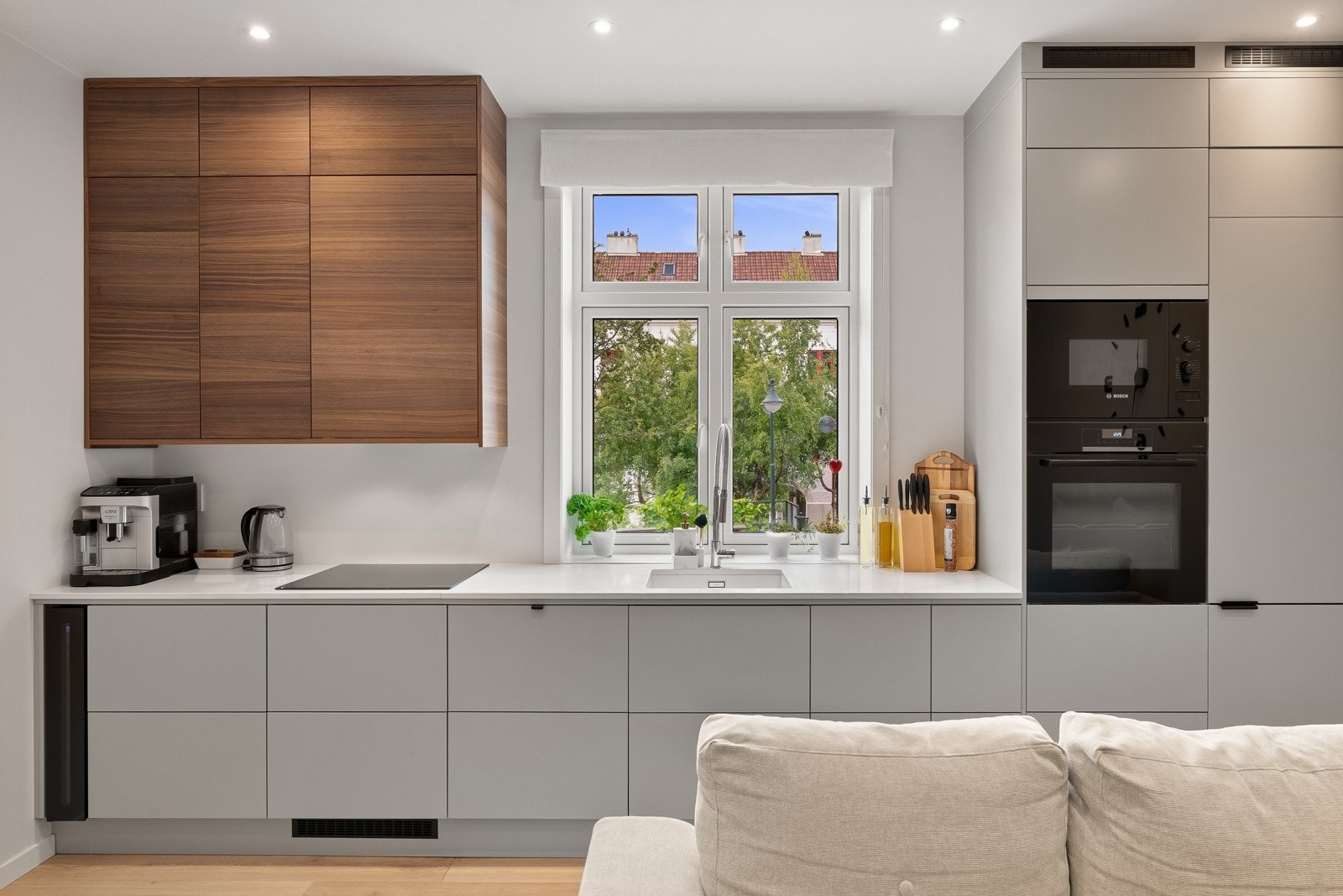 Lekkert og moderne kjøkken som består av glatte fronter og kvarts benkeplate. Galleribilde