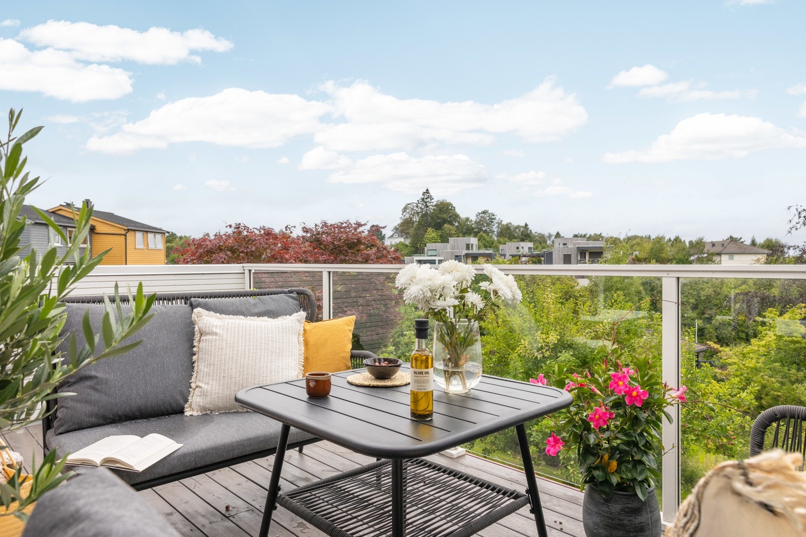 Balkongen er innredet med utemøbler, blomster og vekster. Galleribilde