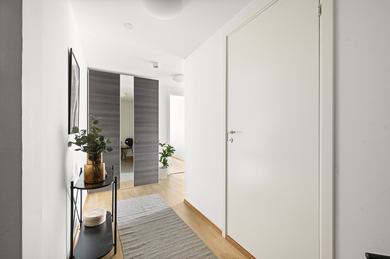 Velkommen inn! Innbydende entré med rom for oppbevaring av yttertøy og sko i garderobeskap. Fra entréen er det videre adkomst til bad, hovedsoverom og stue/kjøkken. Galleribilde