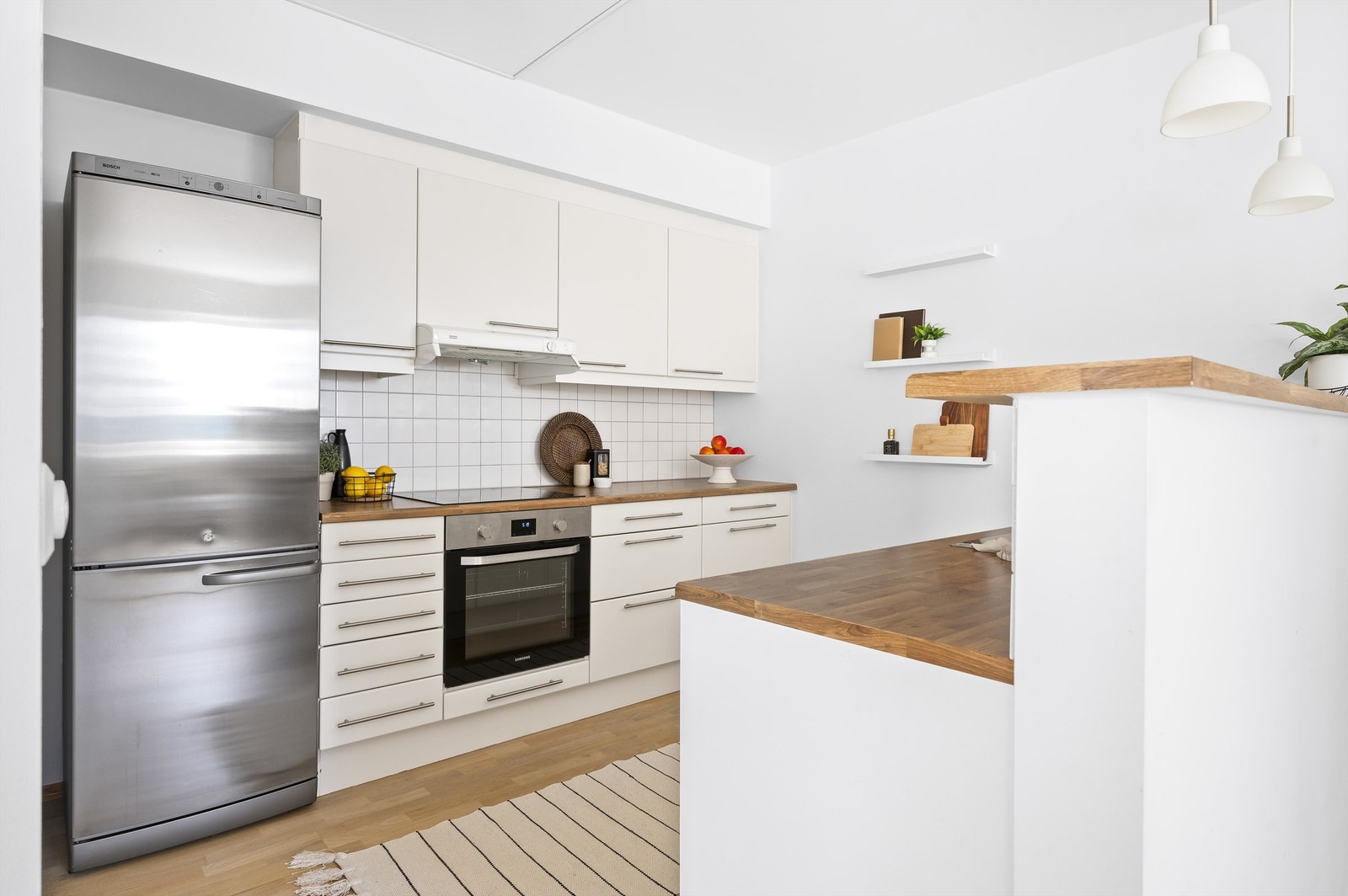 Lyst og pent kjøkken som ligger i delvis åpen løsning mot stue som sørger for både verbal og visuell kontakt, men samtidig skjuler kjøkkenbenk fra stuen. Galleribilde