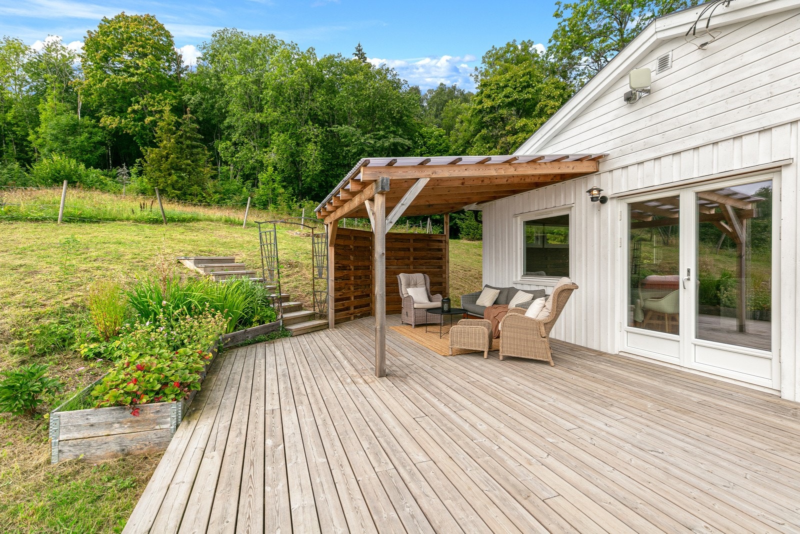Romslig og delvis overbygd terrasse med utgang fra stuen. Galleribilde