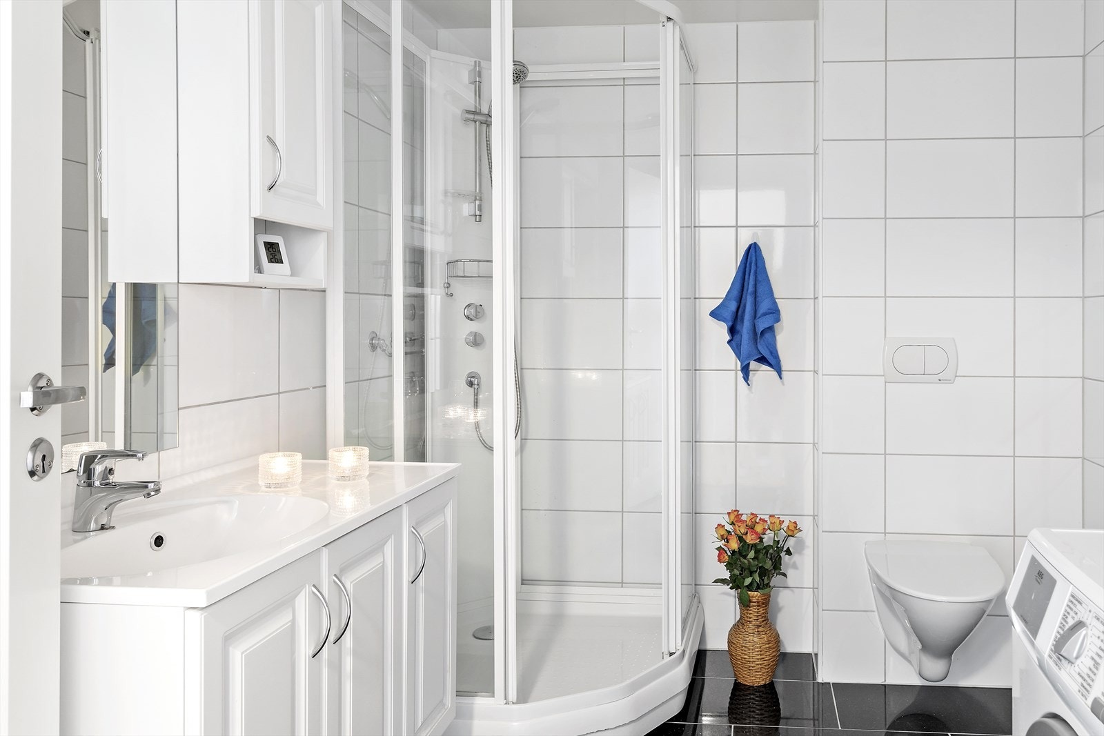 Badet er innredet med dusjhjørne med dusjkabinett, baderomsinnredning med vask og vegghengt toalett. Galleribilde