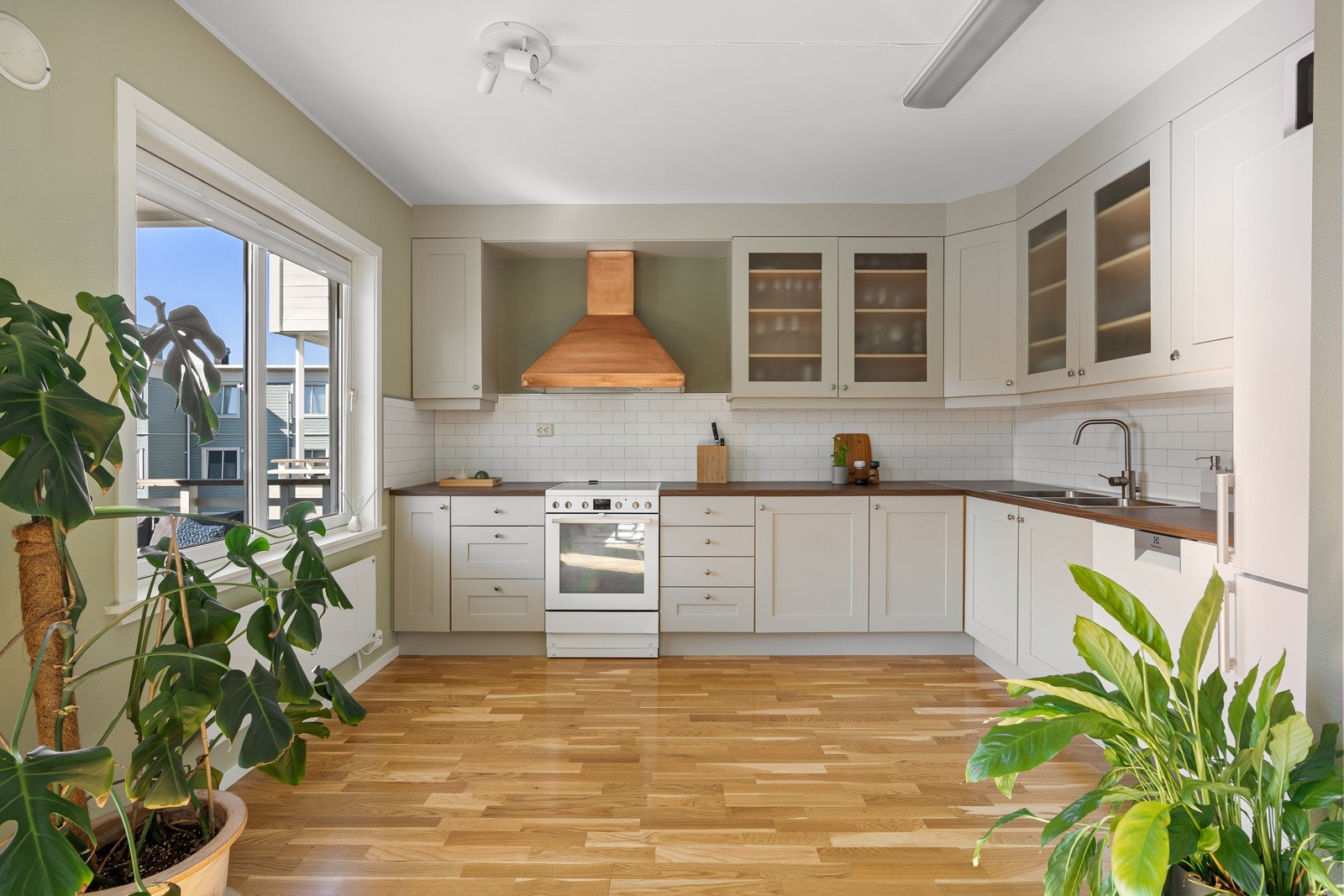 Stue og kjøkken i åpen løsning, samtidig som rommets utforming gjør at de også er litt adskilt. Galleribilde