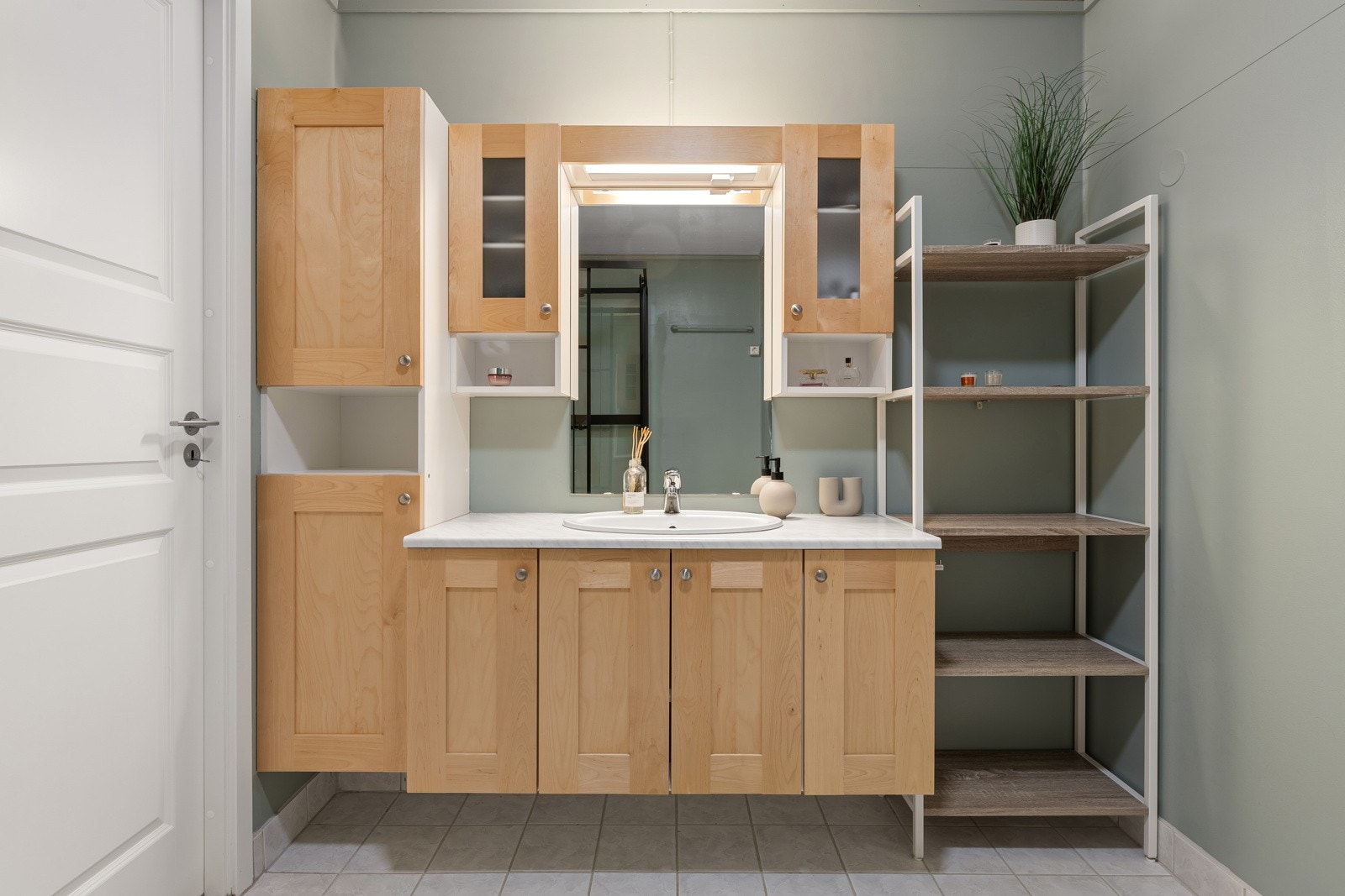 Badet har fliser på gulv med varme og er utstyrt med wc, dusjkabinett og opplegg for vaskemaskin. Galleribilde