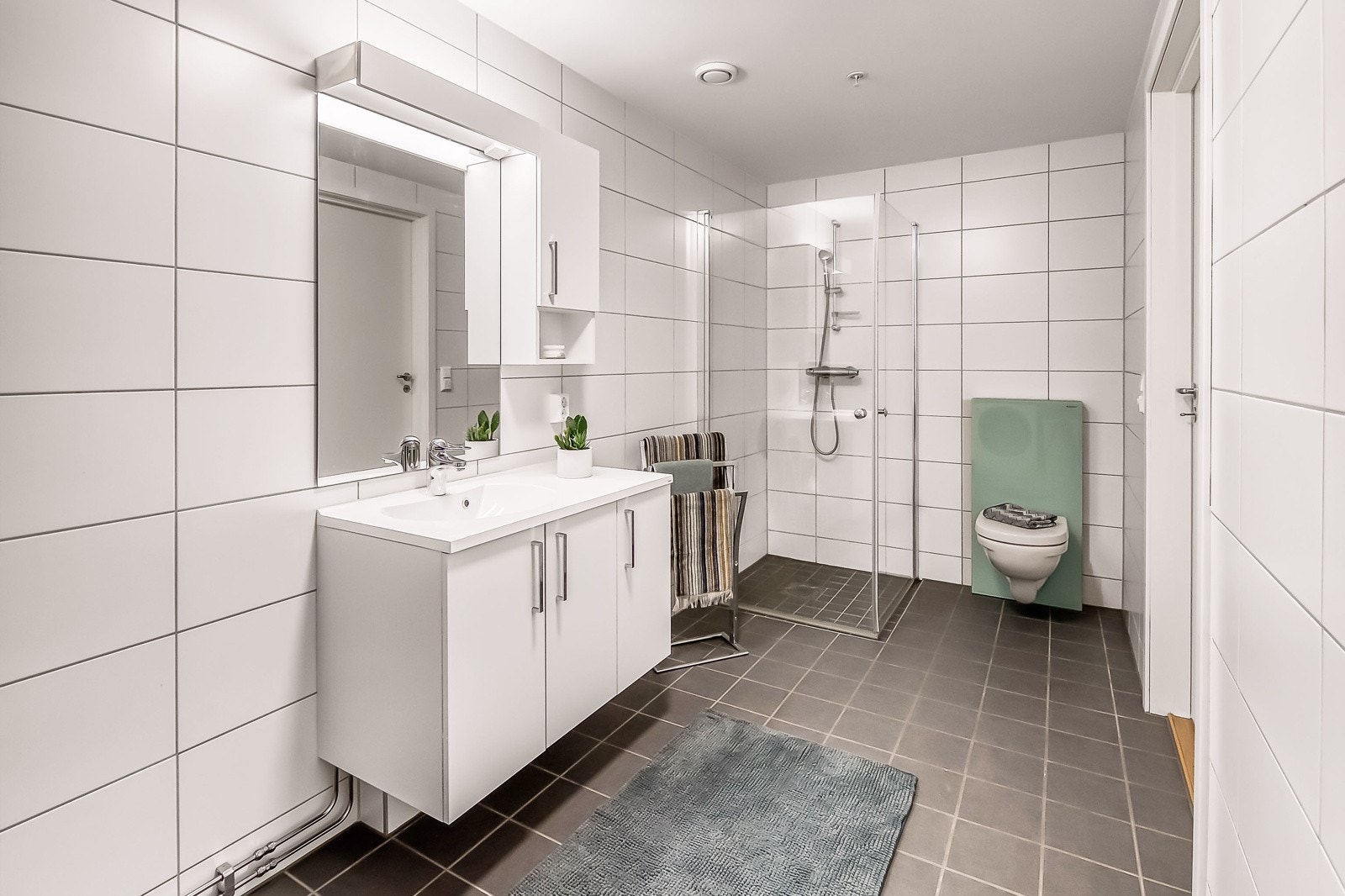 Badet har vegghengt toalett og dusjhjørne m/ glassdører. Galleribilde