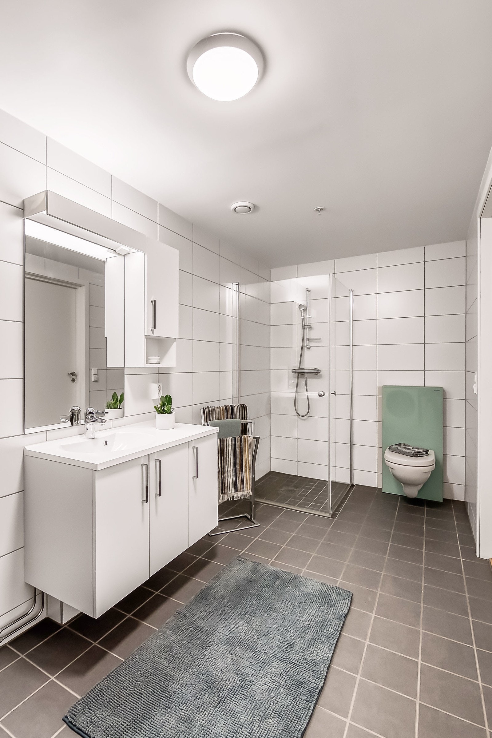 Badet har vegghengt toalett og dusjhjørne m/ glassdører. Galleribilde