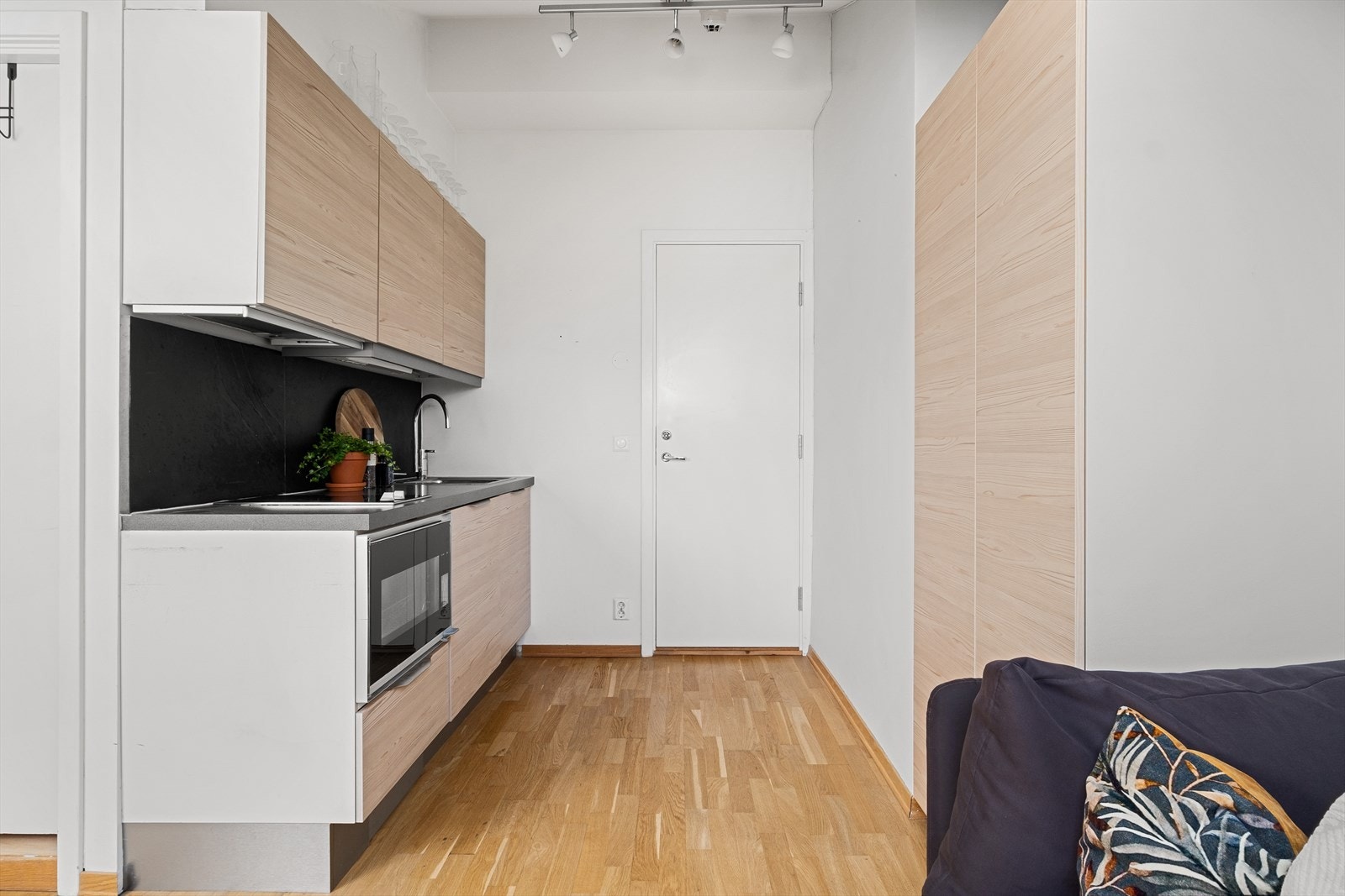 Kjøkkeninnredning med glatte fronter, benkeplate i laminat med kum og ett-greps blandebatteri. Galleribilde