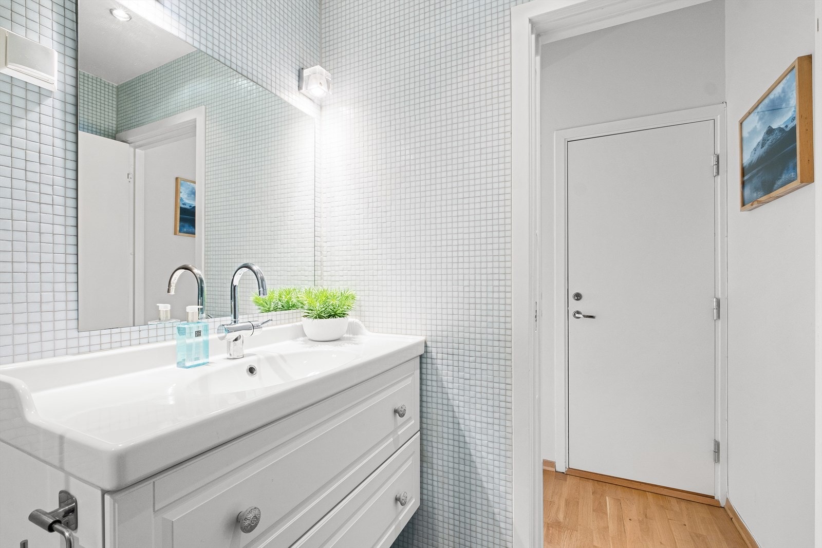 Baderommet inneholder dusjkabinett, wc, servantskap med ett-greps blandebatteri, speil på vegg, belysning og opplegg for vaskemaskin. Galleribilde