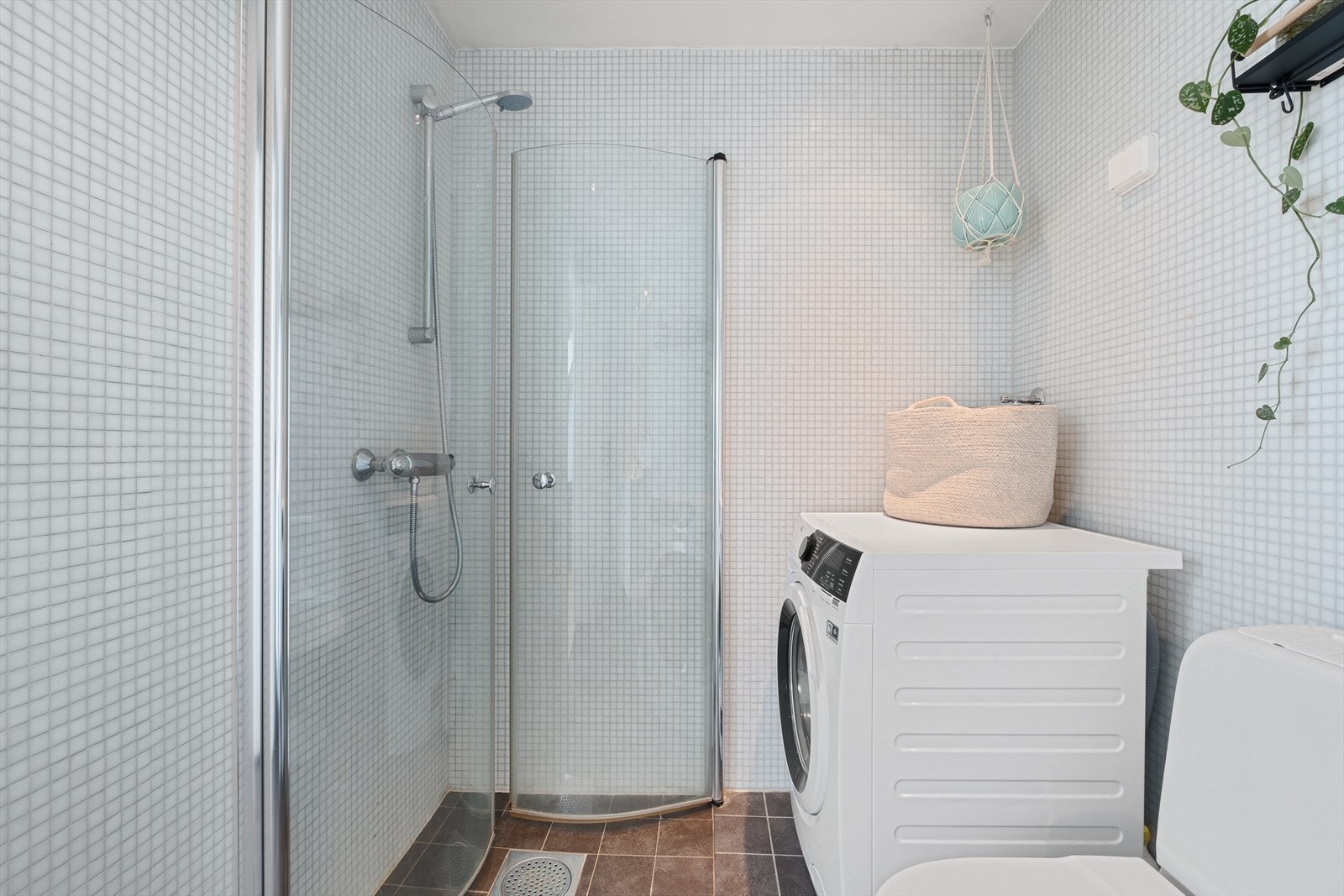 Baderommet inneholder dusjhjørne med innfellbare dører i glass ( dusj rett på gulv), wc, servantskap med ett-greps blandebatteri, speil på vegg, belysning og opplegg for vaskemaskin. Galleribilde