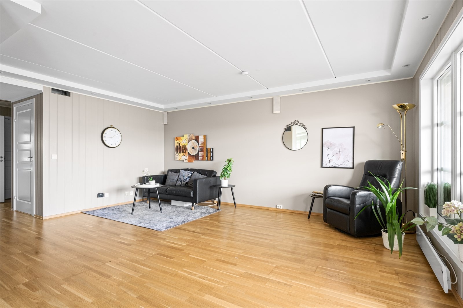 Den innbydende stuen har vinduer fra flere vinkler som bidrar med mye naturlig sollys inn til rommet. Galleribilde