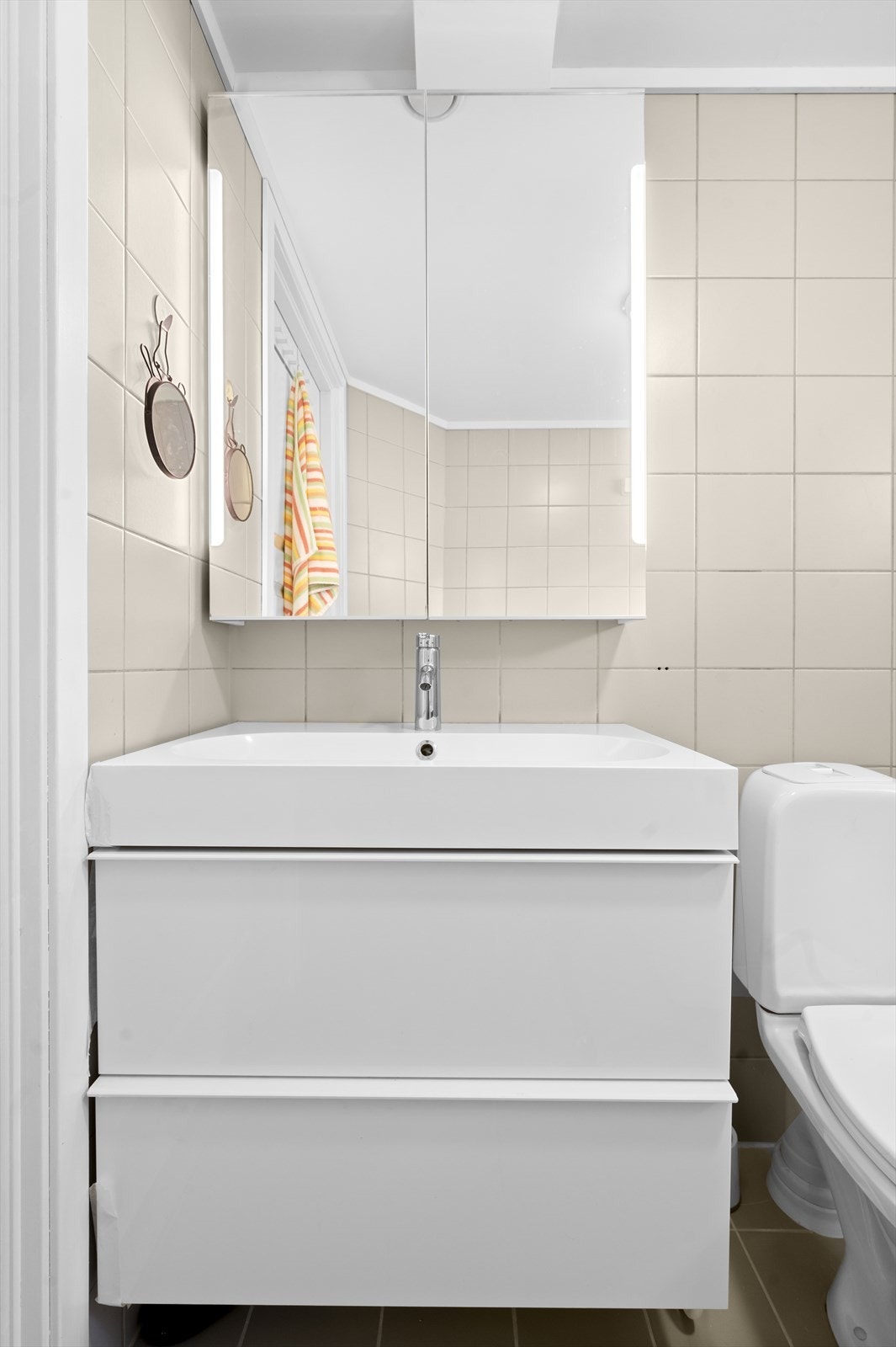 Innredningen består av klosset, servant med innredning, speilskap med lys og dusjhjørne med svingbare glassdører. Galleribilde